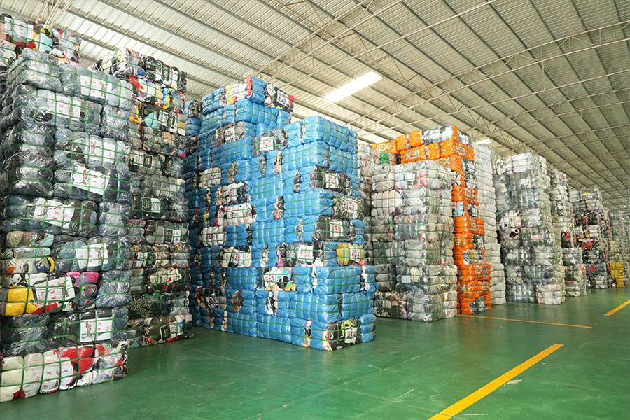 stacks of bales of used shoes sorted by expert sorters