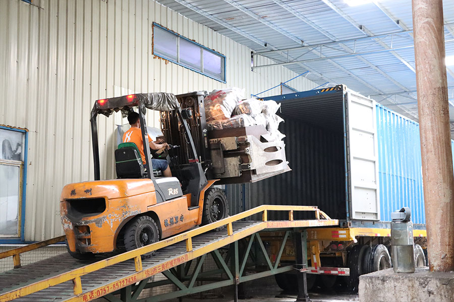 forklift operator loading the bales of used shoes in a cargo container 2
