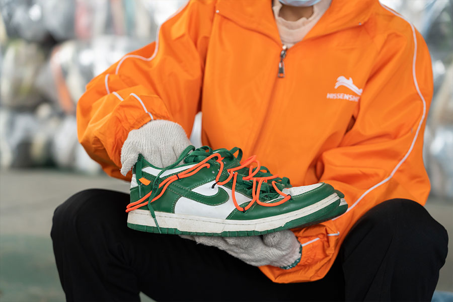 sorter checking the quality of a used shoe pair during the sorting process